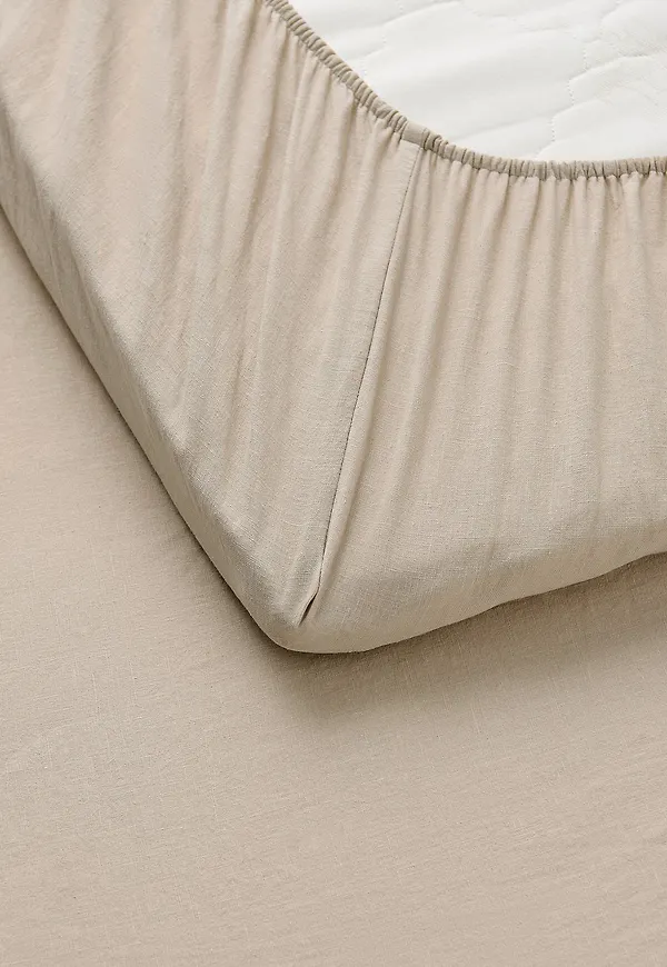 Moderiktig sängkläder i beige färg gjord i bomull.