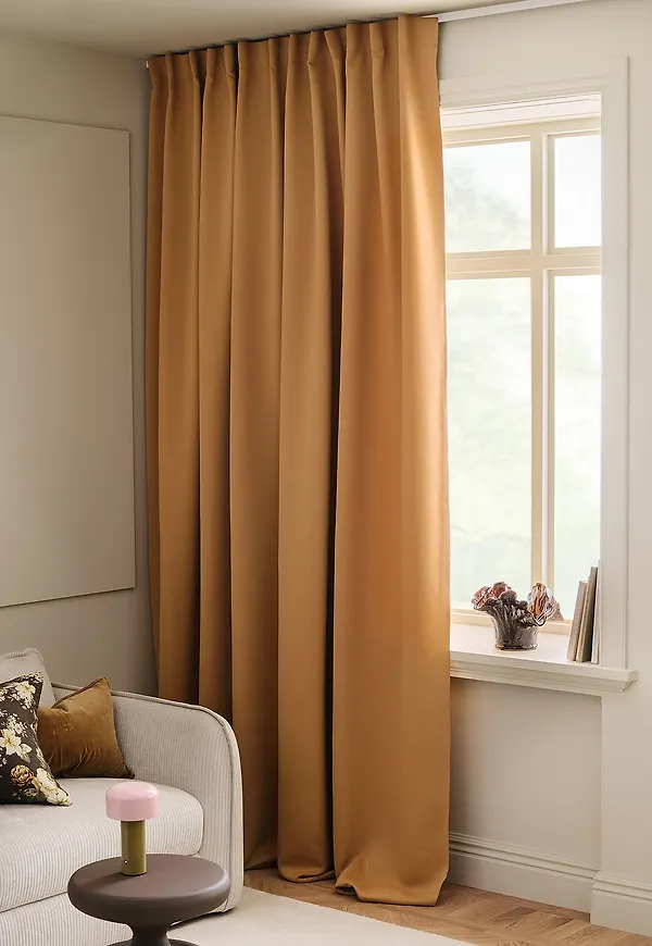 Söt mörkläggningsgardin i oranget från &Home.