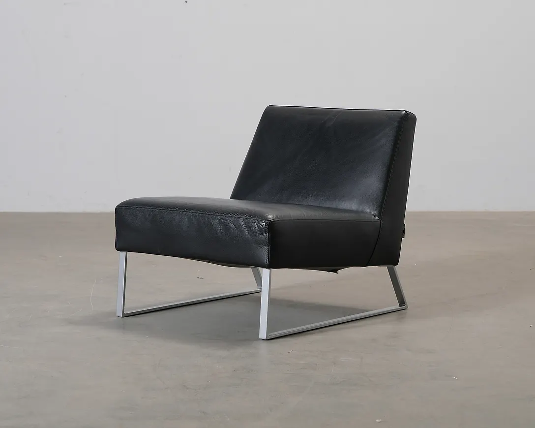 Trendig fåtölj i svart färg gjord i läder.