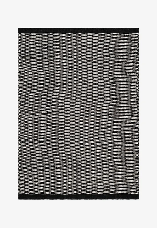 Stilriktig km home matta i svart färg gjord i ull.