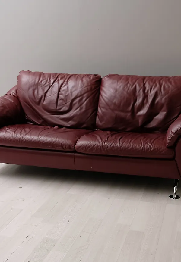 Mysig soffa i vinröd färg gjord i skinn.