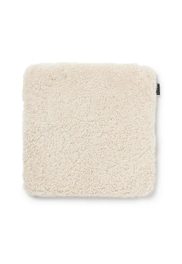 Beige Skinnwille-sittkudde i smickrande modell.