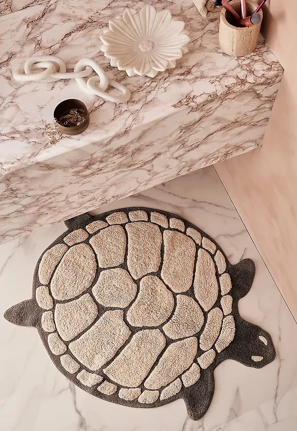 Söt badrumsmatta i rosa färg gjord i bomull.