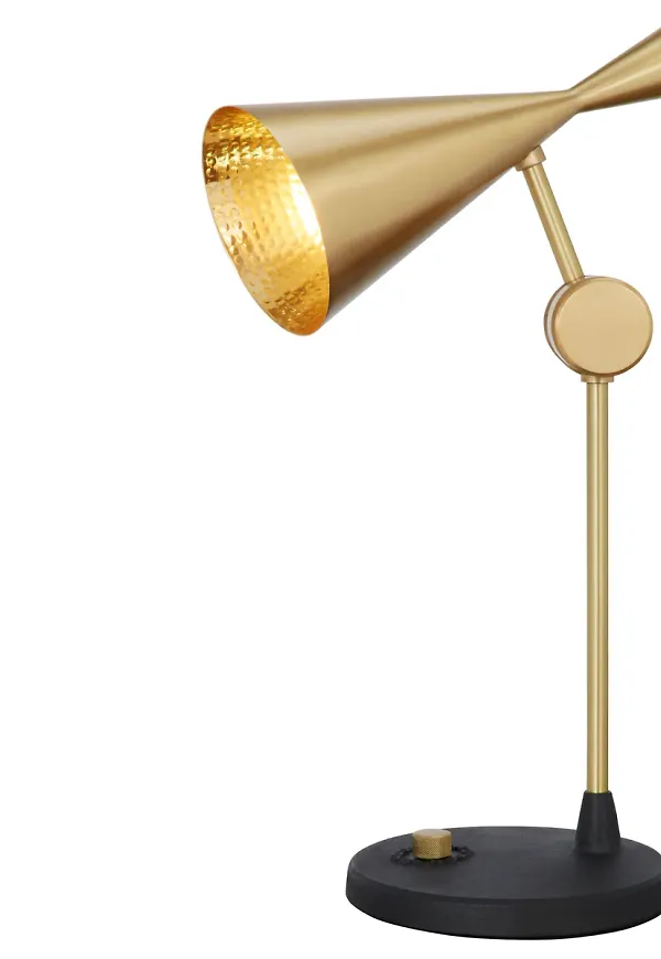Guldfärgad Tom Dixon-bordslampa i modern modell.